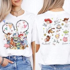 The image is a collage of two photos featuring a white t-shirt with a Disney-themed design. The design includes characters from the Toy Story franchise, such as Woody, Buzz Lightyear, and other beloved characters from the movie.