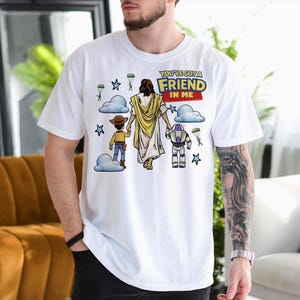 A man wearing a white t-shirt with a graphic design depicting a cartoon character and a message about friendship.