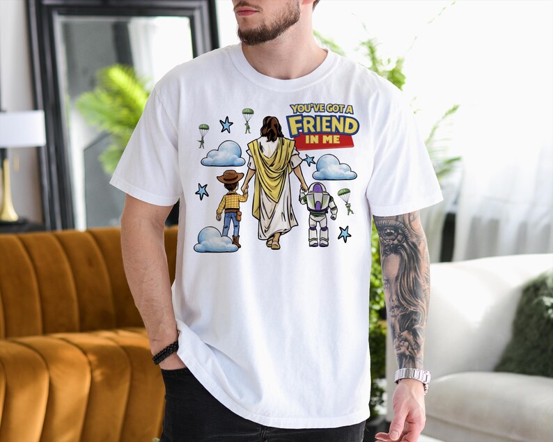 A man wearing a white t-shirt with a graphic design depicting a cartoon character and a message about friendship.