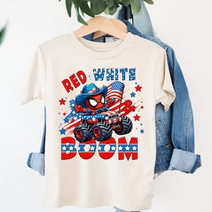 A white t-shirt with a graphic design featuring a Spider-Man character and the text "RED WHITE BOOM" printed on it.