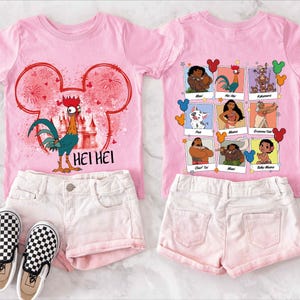 Puede incluir: Camiseta rosa con un gallo de dibujos animados y el texto "Hei Hei" en la parte delantera. La parte posterior de la camiseta presenta una cuadr&iacute;cula de personajes de dibujos animados de la pel&iacute;cula Moana. La camiseta se combina con pantalones cortos de mezclilla blancos.