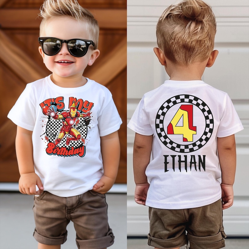 A young boy wearing a white t-shirt with a graphic design and sunglasses, standing in front of a wooden door.