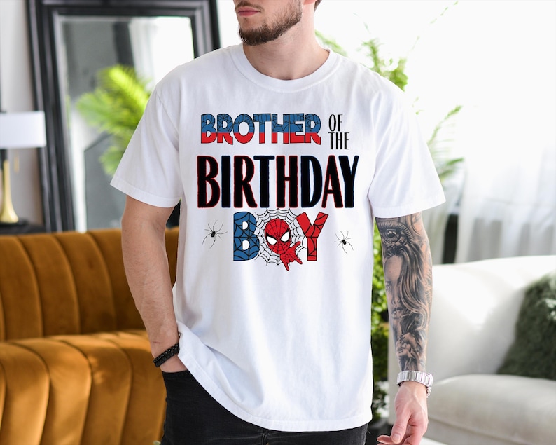 A man wearing a white t-shirt with a graphic design that says "BROTHER OF THE BIRTHDAY BOY" and Spider-Man imagery.