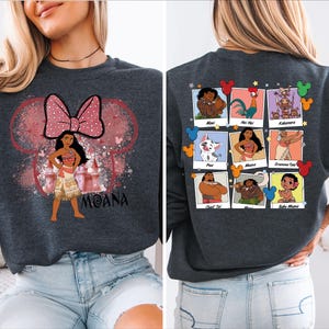 Puede incluir: Una sudadera gris oscuro con un lazo rosa y blanco y una imagen de dibujos animados de Moana de la pel&iacute;cula de Disney Moana. La parte posterior de la sudadera tiene un collage de im&aacute;genes de la pel&iacute;cula, incluyendo Maui, Pua, Hei Hei y Gramma Tala.