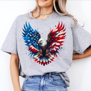 A woman wearing a gray t-shirt with an American eagle design and a flag pattern.