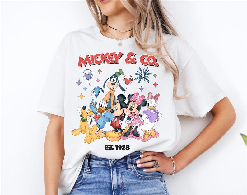 A woman wearing a white t-shirt with a graphic of Disney characters Mickey Mouse and Donald Duck.
