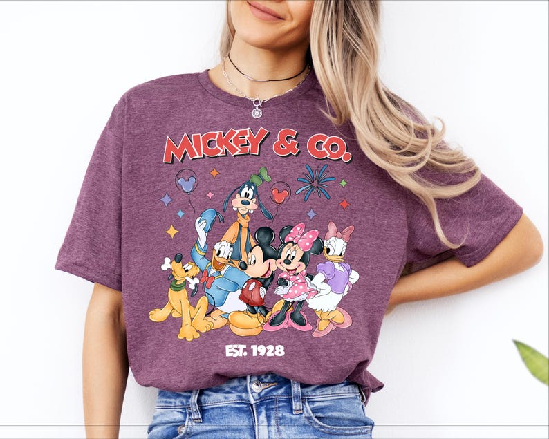 A woman wearing a purple t-shirt with a graphic of Disney characters Mickey Mouse and Co.