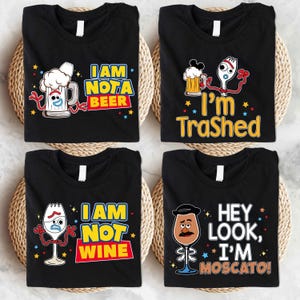 four black t-shirts with colorful and humorous text and illustrations.