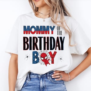 A woman wearing a white t-shirt with the text "MOMMY OF THE BIRTHDAY BOY" printed on it, along with a Spider-Man design.