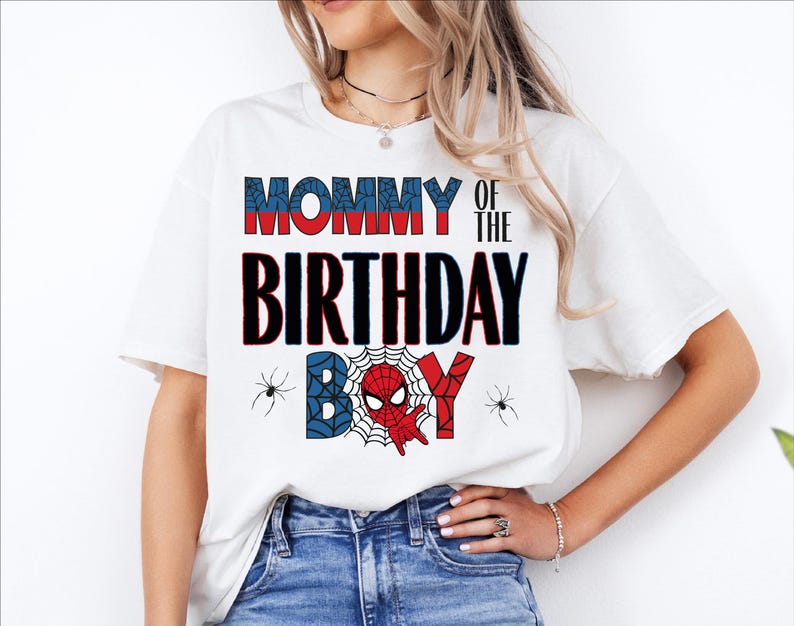 A woman wearing a white t-shirt with the text "MOMMY OF THE BIRTHDAY BOY" printed on it, along with a Spider-Man design.