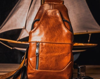 Puede incluir: Un bolso de cuero marrón con cierre de cremallera plateado y correa negra. El bolso está sobre una superficie de madera.