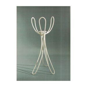 May include: A silver metal candle holder with a unique, abstract design. The holder has a circular top and three legs that curve and intersect.