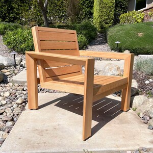 May include: A wooden chair with a slatted back and seat. The chair is made of natural wood and has a simple, modern design.