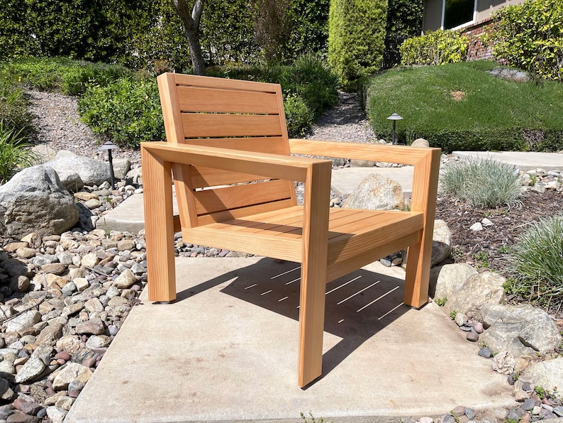 May include: A wooden chair with a slatted back and seat. The chair is made of natural wood and has a simple, modern design.