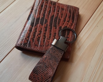 An exclusive wallet and keychain in orange and black, crafted from lizard and African goat leather.
