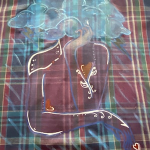 May include: A blue and white painted design on a plaid fabric shirt. The design depicts a person with a cloud for a head, a single arm, and a heart in their hand.