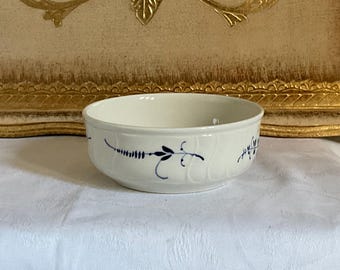 May include: A white ceramic bowl with a blue floral design. The bowl is round and has a slightly flared rim.