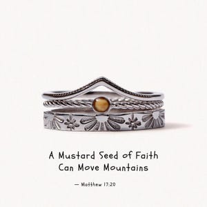 May include: A stack of three silver-toned rings featuring a chevron band, a twisted band with a small round mustard seed inlay, and a flat band with engraved sunburst patterns. Text reads: A Mustard Seed of Faith Can Move Mountains — Matthew 17:20.