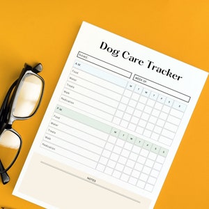 Könnte beinhalten: Ein weißes Dog Care Tracker-Blatt mit einem schwarzen Bleistift und einer schwarz gerahmten Brille auf gelbem Hintergrund. Der Tracker enthält Abschnitte für A.M.- und P.M.-Einträge mit Feldern für Futter, Wasser, Leckerlis, Spaziergang und Medikamente. Das Blatt hat auch Platz für den Namen des Hundes und die Woche.