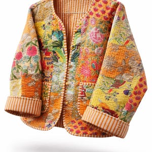 May include: A quilted jacket with a floral patchwork design in shades of orange, yellow, and pink. The jacket features a V-neck, two pockets, and striped cuffs. The interior lining is striped.