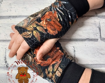 May include: Black fingerless gloves with a floral and spiderweb design. The gloves feature orange poppies, a spider, and autumn leaves on a black background. The cuffs are solid black.