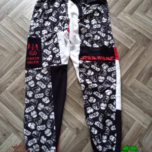 May include: Black and white Star Wars themed sweatpants with a red and white patch on the left leg that says "Darth Vader".