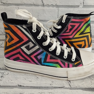 Puede incluir: Zapatillas de lona negras de caña alta con un estampado geométrico colorido en tonos de rosa, naranja, amarillo, azul y verde.