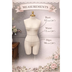 May include: A cream-colored fabric dress form with a gold-toned neck cap. The form displays measurements: bust 36 inches, waist 28 inches, and hips 38 inches. The torso is shaped with visible seams and is mounted on a central vertical metal stand.