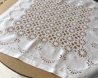 Könnte beinhalten: Weiße Baumwolltischdecke mit einem zarten, filigranen Spitzenmuster mit einem sich wiederholenden Blumendesign. Die Tischdecke hat einen gewellten Rand und ist perfekt für ein formelles Esszimmer.