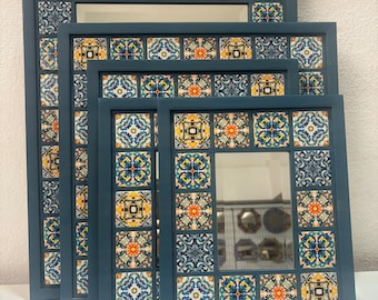 Op de afbeelding: Set van vier blauwe, ingelijste spiegels met kleurrijke tegelontwerpen. De spiegels zijn in elkaar genest, met de grootste spiegel aan de achterkant en de kleinste spiegel aan de voorkant.