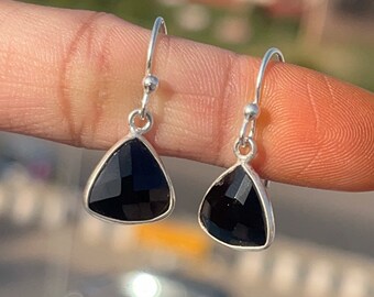 May include: A pair of silver dangle earrings with black triangular gemstone drops.
