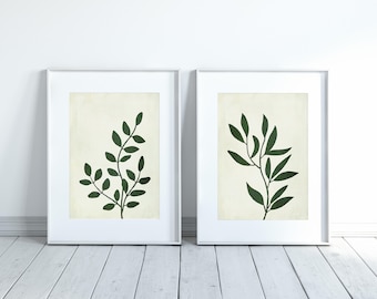 May include: Two framed prints with a minimalist design featuring dark green silhouettes of leafy branches on a cream background.