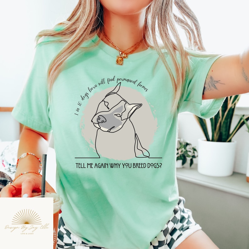 May include: A light green t-shirt with a dog graphic and the text "1 in 10 dogs born will find permanent homes. TELL ME AGAIN WHY YOU BREED DOGS?". The graphic is a line drawing of a dog.