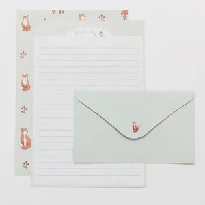 May include: A set of stationery featuring a light green envelope and a matching sheet of writing paper. Both the envelope and paper have a fox illustration and the text "Our happy day" on the paper.