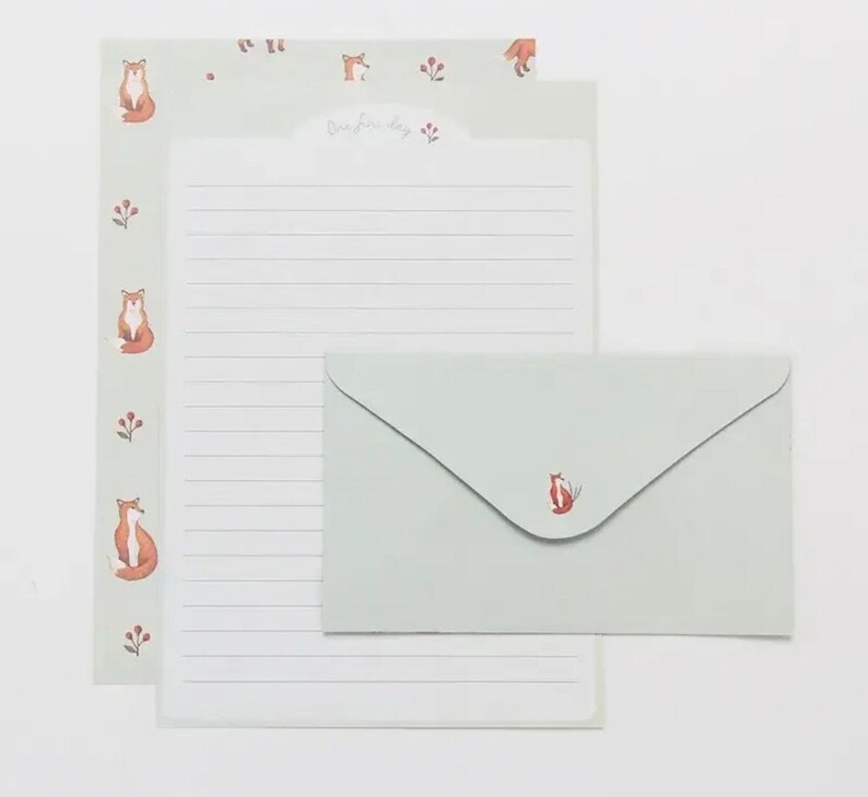 May include: A set of stationery featuring a light green envelope and a matching sheet of writing paper. Both the envelope and paper have a fox illustration and the text "Our happy day" on the paper.