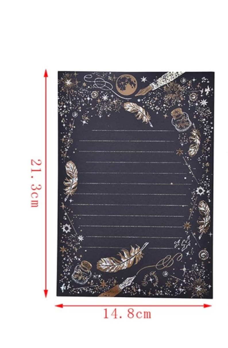 Puede incluir: Papel de papeler&iacute;a negro con detalles dorados, de 14,8 cm de ancho y 21,3 cm de alto. El dise&ntilde;o presenta plumas, estrellas, una luna y una botella. El papel tiene secciones rayadas para escribir.