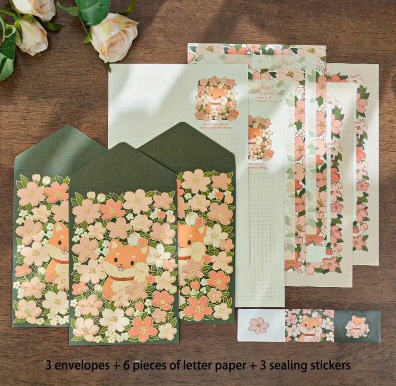 Pu&ograve; includere: Un set di tre buste verdi con un motivo floreale con fiori rosa e un cane Shiba Inu di cartone animato. Il set include anche sei fogli di carta da lettere con un bordo floreale e tre adesivi di sigillatura con un motivo floreale.