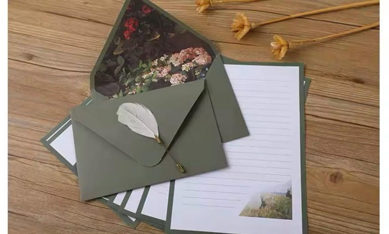 Pu&ograve; includere: Un set di cartoleria verde con un design floreale sulla busta. La cartoleria include un foglio di carta rigata e una busta bianca.
