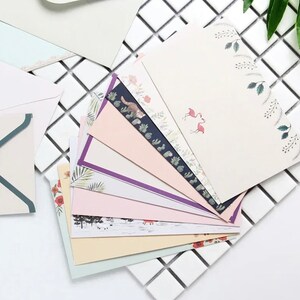 May include: A stack of colorful stationery cards with various floral and animal designs. The cards have a white background with a decorative border.