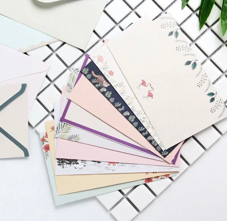 May include: A stack of colorful stationery cards with various floral and animal designs. The cards have a white background with a decorative border.