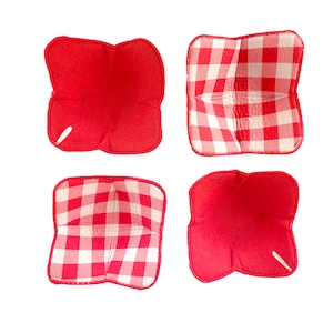 Puede incluir: Cuatro agarraderas de olla de tela de cuadros rojos y blancos. Dos son de color rojo sólido y dos tienen un patrón de cuadros.