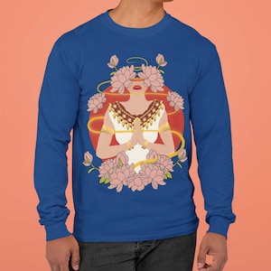 May include: A royal blue long-sleeve t-shirt with a graphic of a woman with closed eyes and hands clasped in prayer. The woman is surrounded by pink flowers and a red and gold circle.