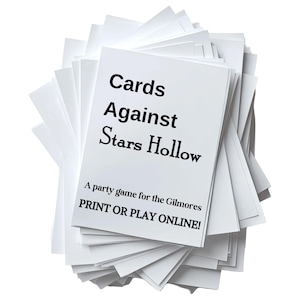 May include: A stack of white rectangular cards with black text that reads Cards Against Stars Hollow, A party game for the Gilmores, and PRINT OR PLAY ONLINE! The cards are arranged in a fanned-out pile, showing multiple blank white cards.