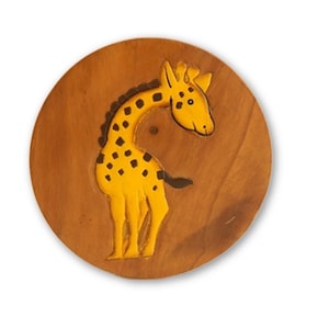 May include: A circular wooden plaque with a carved yellow giraffe with black spots. The giraffe is set against a brown background. This decorative item could be used as a wall hanging or a child's room decoration.