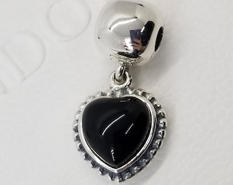 May include: A silver charm with a black heart pendant. The heart has a silver border with a decorative edge.