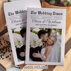 May include: A white card with a newspaper-style design announcing a wedding. The card features a photo of a couple kissing and the text "The Wedding Times, New York, NY, Special Edition, October 2025, Olivia & William Are Getting Married! and you're invited!" The card also includes the text "seeds included" at the bottom.