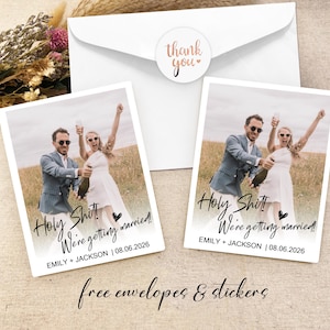 May include: Two wedding announcement cards with a photo of a couple in a field. The cards are white with black text that says "Holy Shit! We're getting married!" and includes the couple's names and wedding date.