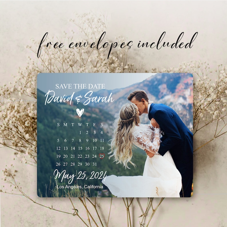 May include: Save the date card with a photo of a couple kissing in front of a mountain range. The card features a calendar with the date May 25, 2024 circled in red. The text "David & Sarah" is written in white script with a heart symbol.
