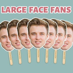 May include: A collection of face fans featuring a smiling man's face. Each fan is mounted on a wooden stick and has the text "Forever in love". The words "LARGE FACE FANS" are displayed at the top in a pink font.