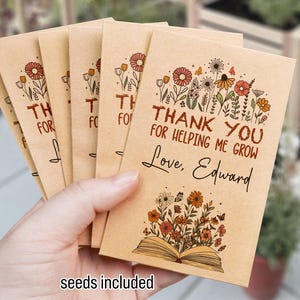 May include: A set of six brown paper seed packets with a floral design and the text "Thank You for Helping Me Grow Love, Edward".